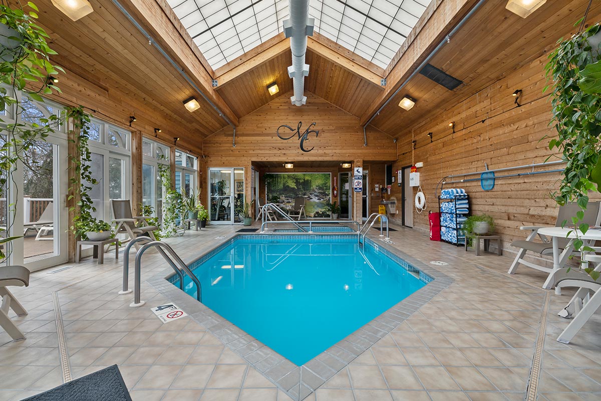 Amenities at The Mill Creek Hotel and Suites in Lake Geneva Wisconsin include a indoor solarium with pool and whirlpool hot tub